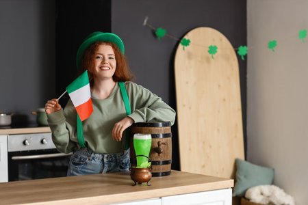 Young woman with Irish flag and beer in kitchen. St. Patrick's Day celebration