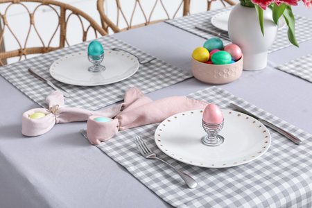 Table setting with Easter eggs in kitchen, closeup