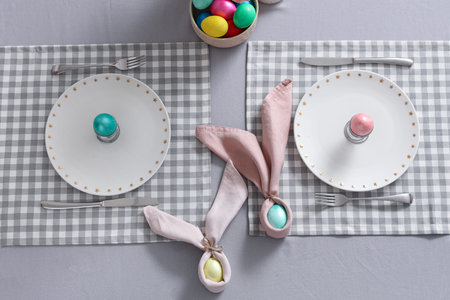 Table setting with Easter eggs in kitchen, top view