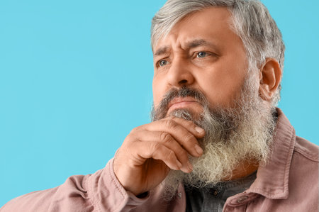 Portrait of sad senior man on blue background, closeupの写真素材