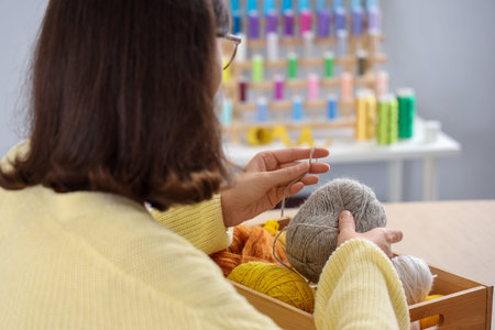 Young woman with knitting yarn at home, closeup