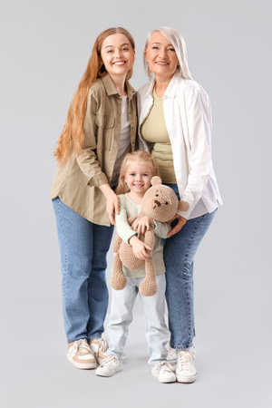 Little girl with her mom and grandmother on light background