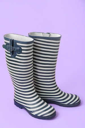 Stylish gumboots on lilac backgroundの写真素材