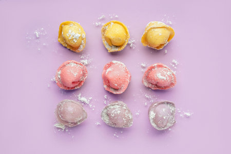 Colorful raw dumplings on purple background