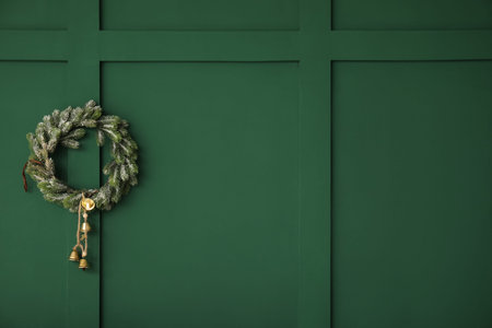 Christmas wreath hanging on green wallの写真素材