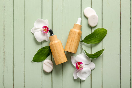 Composition with bottles of cosmetic products, spa stones and orchid flowers on color wooden backgroundの写真素材