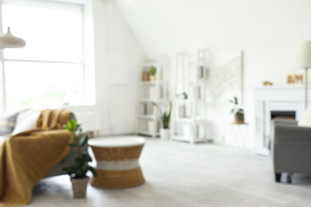 Blurred view of light living room with sofas and shelf units