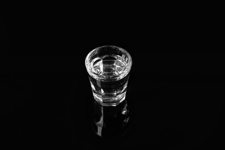 Shot of cold vodka on black background
