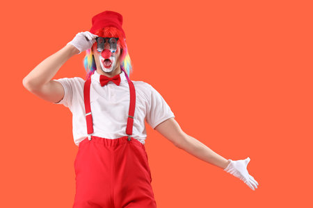 Portrait of clown with novelty glasses on orange background. April Fool's day celebrationの写真素材