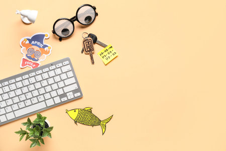 Carton key, sticky note and computer keyboard on beige background. April Fools Day prank