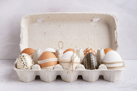 Paper holder with decorated Easter eggs on white background