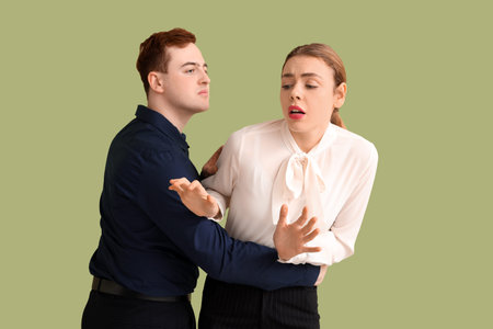 Business man molesting his female colleague on green background. Harassment concept