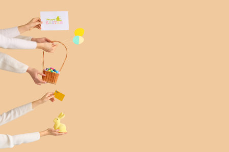 Women with credit card and Easter decor on beige background. Online shopping