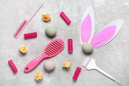 Hairdressing accessories with roses, Easter eggs and paper bunny ears on gray grunge backgroundの写真素材
