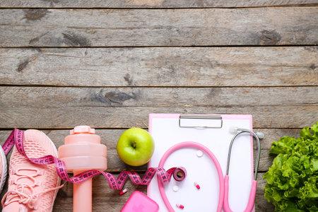 Composition with clipboard, measuring tape, stethoscope and healthy food on wooden backgroundの写真素材