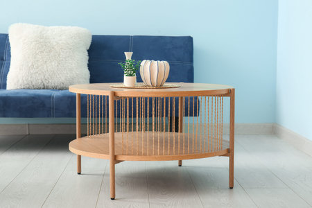 Wooden coffee table with decor and sofa near blue wallの写真素材
