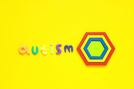 Word AUTISM and toys on yellow backgroundの写真素材