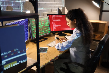 Female African-American programmer looking at smartwatch in office