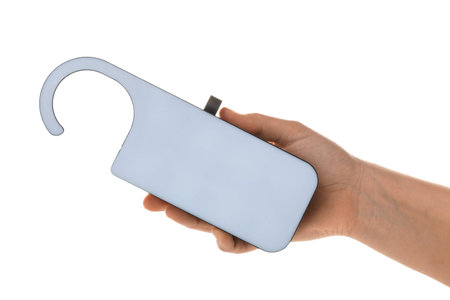 Female hand holding hotel door hanger on white backgroundの写真素材