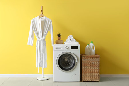 Interior of laundry room with wicker basket, washing machine and bathrobe