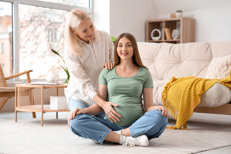 Young pregnant woman with doula sitting at home