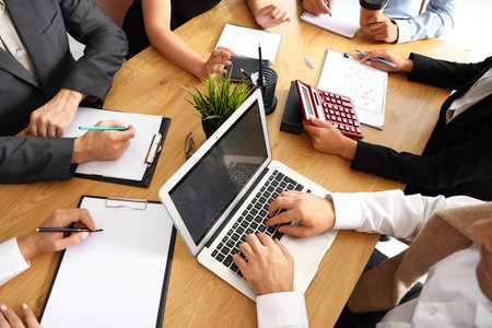 Businessman working with laptop at table in conference hall, closeup