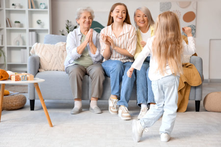 Little girl with her family dancing at home, back view