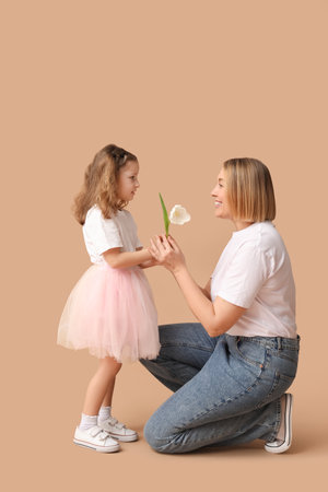 Little girl giving flower to her mother on beige background. Mother's Dayの写真素材