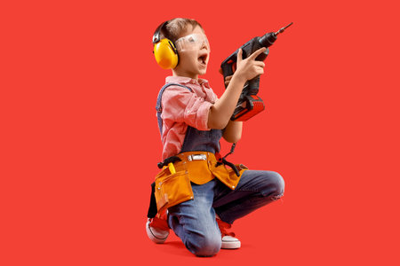 Cute little builder with drill on red background