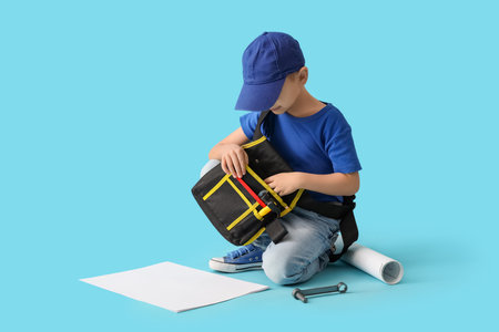 Cute little builder with bag of tools on blue backgroundの写真素材