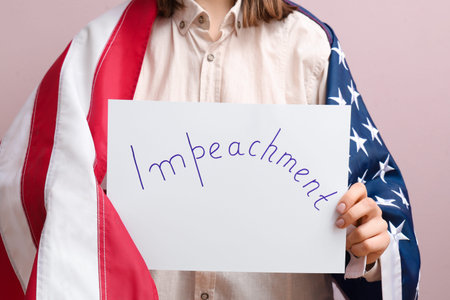Woman with USA flag holding IMPEACHMENT picket sign on pink backgroundの写真素材