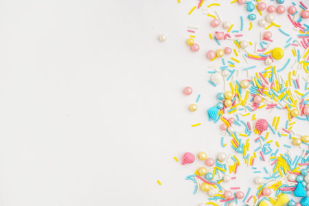 Sweet colorful sprinkles scattered on white background