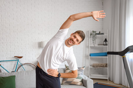Sporty young man doing exercise at homeの写真素材