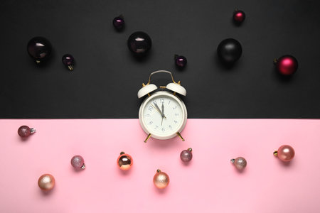 Alarm clock with Christmas balls on colorful backgroundの写真素材