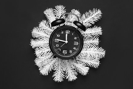 Composition with alarm clock and white fir branches on dark backgroundの写真素材