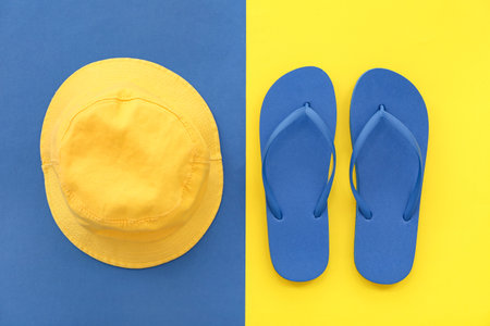 Pair of blue flip flops and panama on colorful backgroundの写真素材