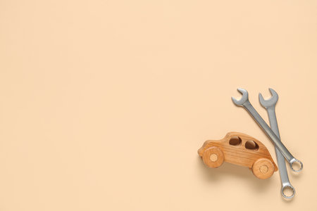 Wrenches and toy car on beige background. Mechanic conceptの写真素材