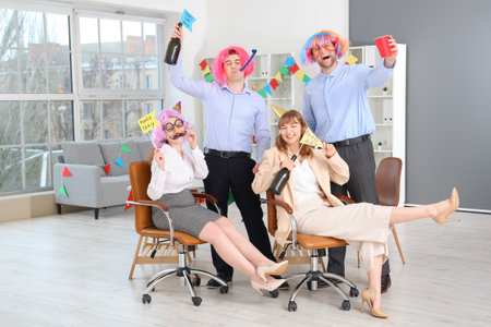 Business colleagues with drink celebrating April Fools' Day at office partyの写真素材