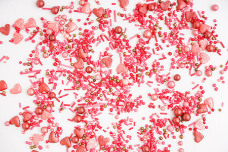 Sweet pink sprinkles scattered on white backgroundの写真素材