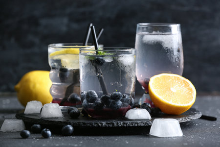 Board with glasses of fresh blueberry lemonade on black backgroundの写真素材