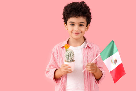 Little boy with Mexican flag and cactus on pink backgroundの写真素材