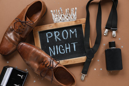 Chalkboard with text PROM NIGHT, male shoes and suspender on brown backgroundの写真素材