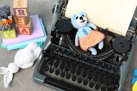 Vintage typewriter and knitted toys on gray grunge backgroundの写真素材