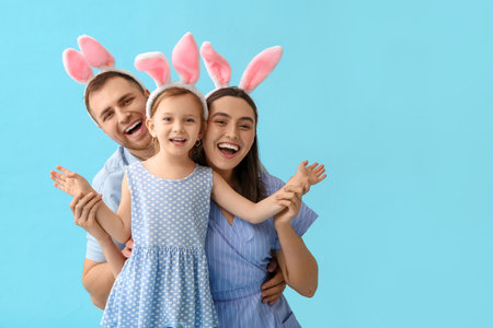 Happy family in Easter bunny ears on blue backgroundの写真素材
