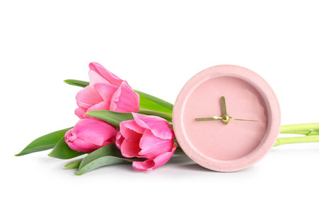 Alarm clock and tulip flowers on white background