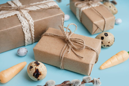 Easter gift boxes with eggs and branch of pussy willow on blue backgroundの写真素材