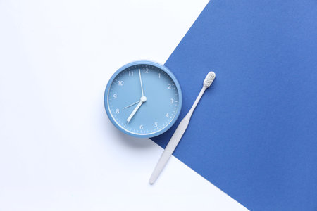 Clock and toothbrush on color backgroundの写真素材