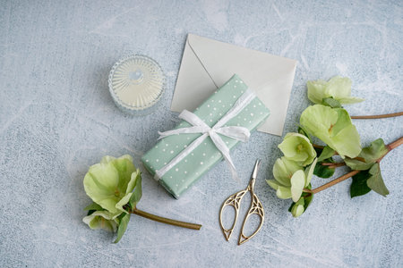 Gift box with beautiful flowers, envelope and candle on grunge backgroundの写真素材