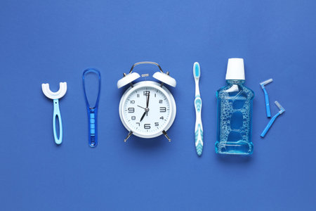 Alarm clock and set for oral hygiene on blue backgroundの写真素材
