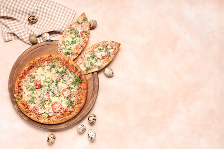 Board with tasty pizza with Easter bunny ears and eggs on beige grunge backgroundの写真素材